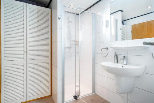 a white bathroom with a sink and a shower at Landhaus Familie Allgeier in Holtgast