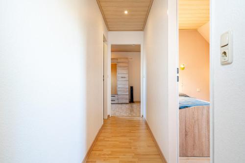 a hallway leading to a bedroom with a bed in a room at Landhaus Familie Allgeier in Holtgast