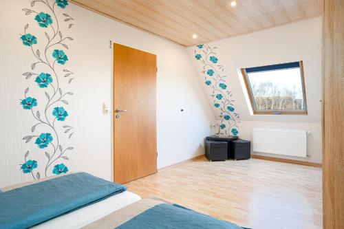 a bedroom with blue flowers on the wall at Landhaus Familie Allgeier in Holtgast