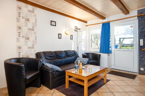 a living room with leather furniture and a table at Landhaus Familie Allgeier in Holtgast