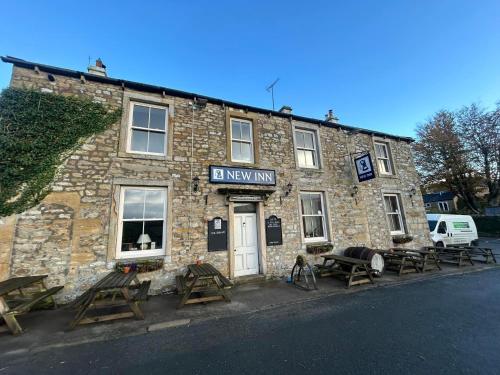 a stone building with picnic tables in front of it at New Inn Appletreewick in Appletreewick