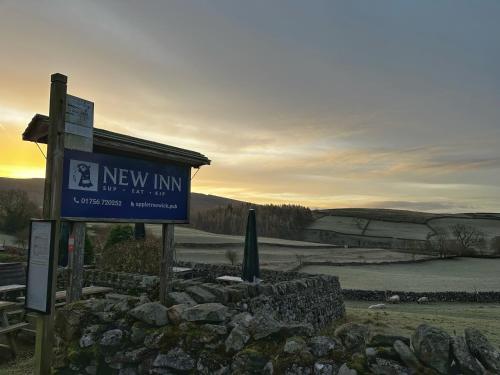 a sign for a new inn next to a lake at New Inn Appletreewick in Appletreewick