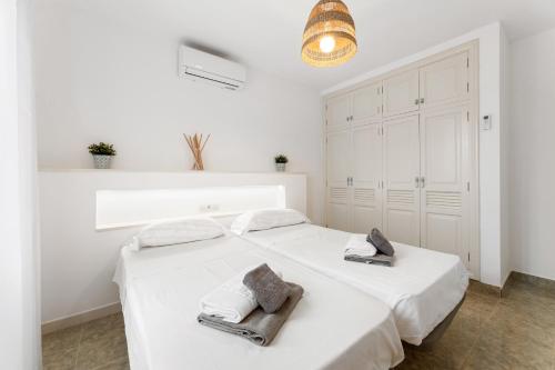 a white bedroom with two beds and a chandelier at Villa 3 VipVipVillas in Tías