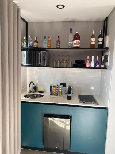 a kitchen with a counter with bottles and a sink at Hotel Living 35 Suites Piso 8 Vip in Medellín
