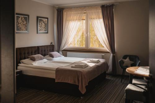 a bedroom with a large bed with a window at Villa Paula in Polanica-Zdrój
