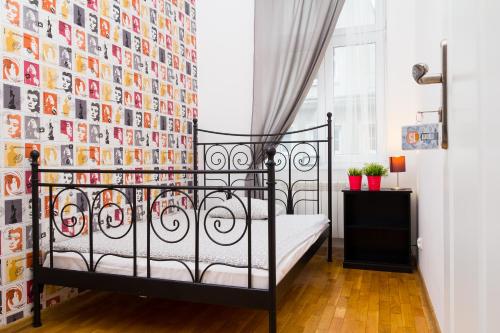 a bedroom with a black bed and a wall of pictures at Retro Hostel in Poznań