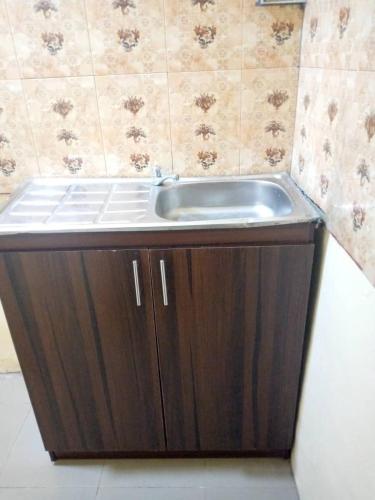 a sink in a bathroom with a brown cabinet at 1 bedroom and living room in Otta