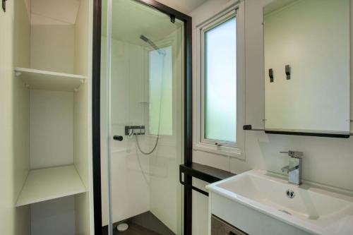 une salle de bain avec un lavabo, une douche et un miroir dans l'établissement Camping du Lac de Grolejac, à Groléjac