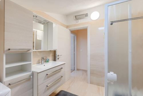 a bathroom with a sink and a shower at Modernes Apartment mit traumhafter Aussicht, Pool, Privatparkplatz, WiFi in Pazin
