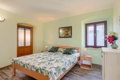 a bedroom with a bed and a window at Mediterranes Apartment mit Panoramablick, Pool, Privatparkplatz, Grill in Pazin