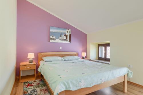 a bedroom with a large bed with purple walls at Beeindruckendes Apartment mit Panoramablick, Pool, Privatparkplatz, Grill in Pazin
