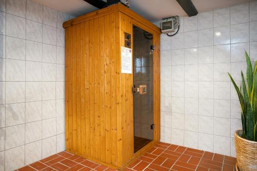 a shower with a wooden door in a bathroom at Landhaus Familie Allgeier in Holtgast