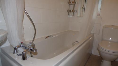 Un baño con bañera y WC. en Byron House, en Chesterfield