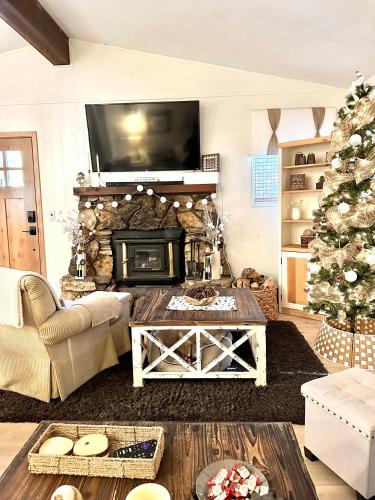 a living room with a fireplace and a christmas tree at The Aspen House in Tahoma