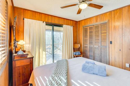 a bedroom with a bed with a ceiling fan and a window at Birdwatching, Board Games and BBQs Cabin in Murphy! in Salem