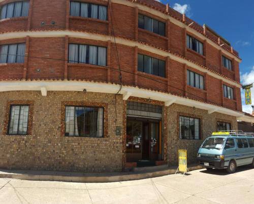 a van parked in front of a brick building at Hotel Utama in Copacabana