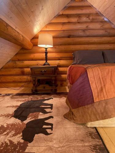 a bedroom with a bed in a log cabin at Log lofted rustic cabin in woods in Kelowna