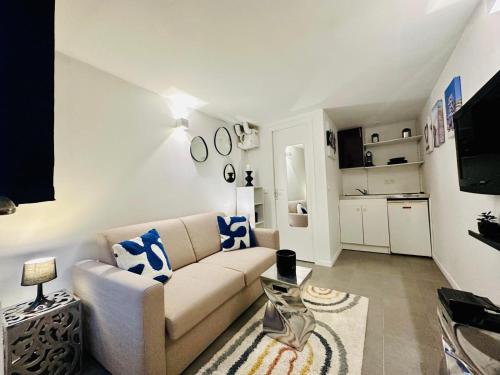 un salon avec un canapé et une cuisine dans l'établissement Le Duo d'Asnières - Double studio avec extérieur, à Asnières-sur-Seine