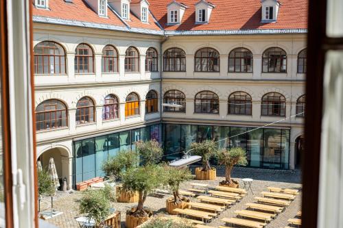 a large building with benches in front of it at Emerald Design - Historic City Center with Free Parking & Panoramic View by HERO HOMES in Graz
