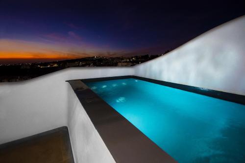 a swimming pool on the side of a building at night at Aegean Blue Suites in Pirgos