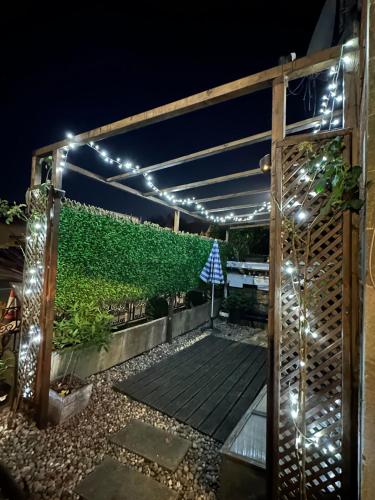 a pergola with lights on a patio at night at Park Terrace Family Room in Glastonbury