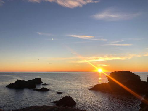 a sunset over the ocean with rocks in the water at Cabo de Palos VVMU 4780-1 in Cabo de Palos
