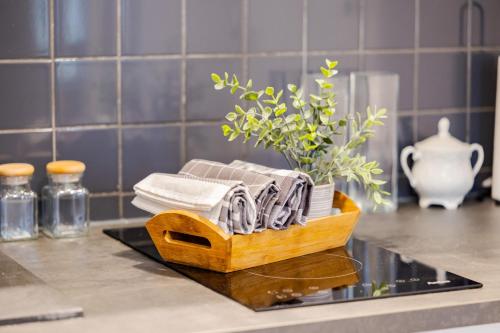 a wooden tray with towels and a plant on a counter at Time Apartment,Parking,Wi-Fi in Łódź