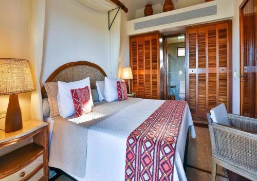 a bedroom with a bed and a table and a lamp at Transamerica Comandatuba - All Inclusive Resort in Ilha de Comandatuba