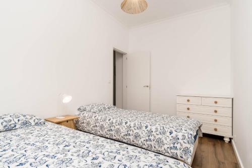 a bedroom with two beds and a dresser at Lovely 2 Bedroom Apartment in Caparica in Almada