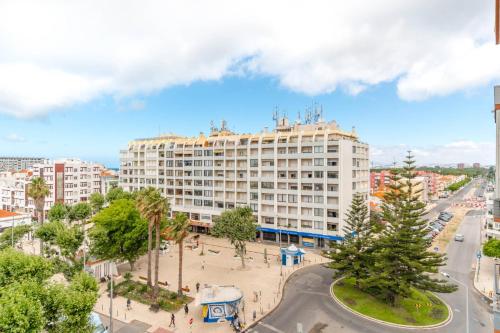 a large white building in a city with a street at Lovely 2 Bedroom Apartment in Caparica in Almada