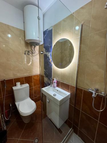 a bathroom with a toilet and a sink and a mirror at Beach Front Superior Apartment Blue Marine in Durrës
