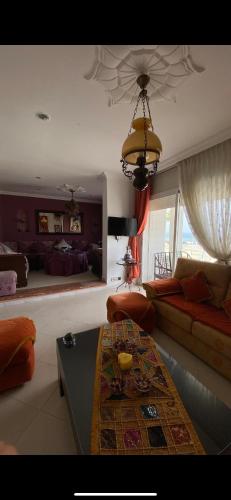 a living room with a couch and a table at appartement pieds dans l'eau in Martil