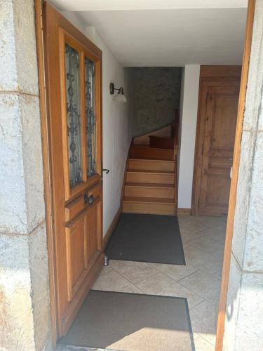 - l'entrée d'une maison avec une porte en bois et des escaliers dans l'établissement Les Chanterelles Montmin, à Plan Motmin