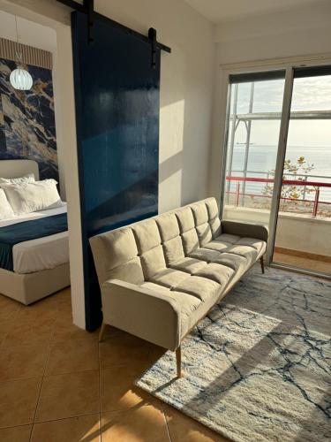 a living room with a couch and a bed at Beach Front Superior Apartment Blue Marine in Durrës