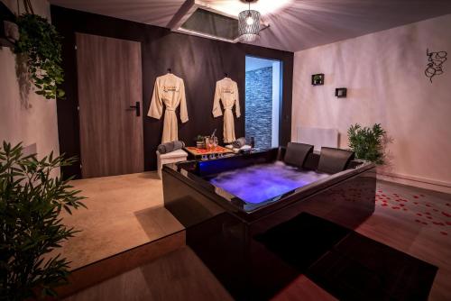 - un bain à remous dans une pièce avec des vêtements accrochés au mur dans l'établissement One Love Room, à Pont-dʼAin