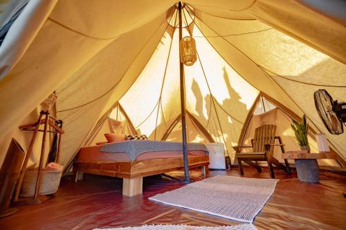 a bedroom in a tent with a bed in it at Eco Luxe Glamping Tent - King Bed at Holos in Barú