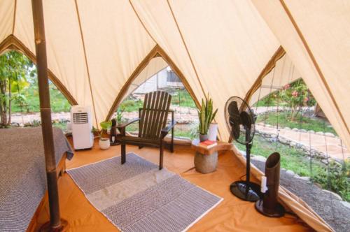 a tent with a chair and mats in a room at Eco Luxe Glamping Tent - King Bed at Holos in Barú