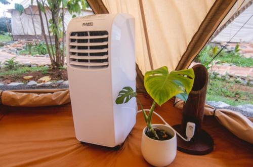 a air conditioner and a potted plant on a table at Eco Luxe Glamping Tent - King Bed at Holos in Barú