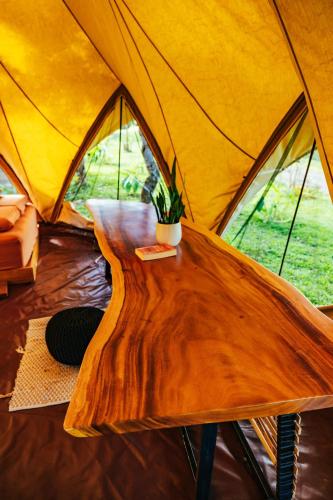a wooden table in front of a tent at Eco Luxe Glamping Tent - King Bed at Holos in Barú