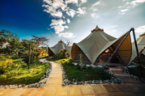 a group of tents in a field with a sky at Eco Luxe Glamping Tent - King Bed at Holos in Barú