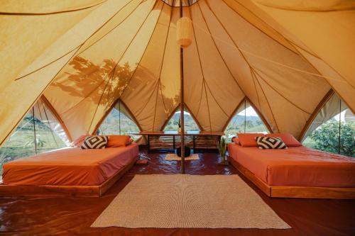 a room with two beds in a tent at Eco Luxe Glamping Tent - 2 Queen Beds at Holos in Barú