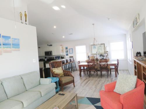a living room with a couch and a dining room at Porch Song in Kitty Hawk