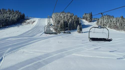 a ski lift going up a snow covered slope at Rezort pod Roháčmi in Vitanová