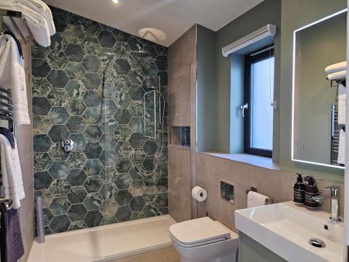 a bathroom with a shower and a toilet and a sink at Woodland Lodge in Huntly