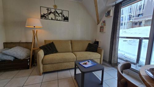 a living room with a couch and a table at Cosy'PY in Bagnères-de-Bigorre