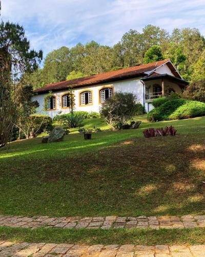 a house with a green yard in front of it at Hotel Fazenda São Francisco in Cunha