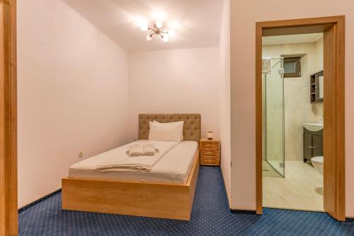 een kleine slaapkamer met een bed en een douche bij Pensiunea Lara in Rîşnov