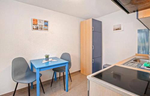 a small kitchen with a blue table and chairs at Ferienwohnung Waren Müritz in Waren
