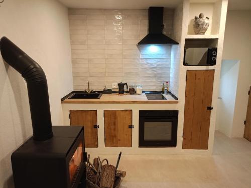 a kitchen with a stove and a sink and a counter at Ao Carón do Camiño in Padrón