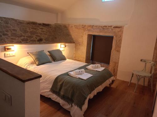 a bedroom with a bed with two towels on it at Ao Carón do Camiño in Padrón